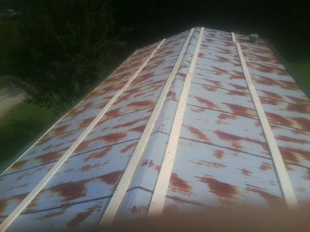 Rusted metal roof panels with new wood purlins before replacement — Storm Damage Roof Repair in Lolo by Roofing Brothers