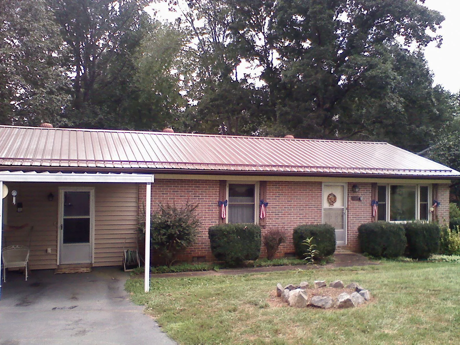 Bronze metal roof and carport on a brick ranch home — Roof Repair work by our crew in Lolo